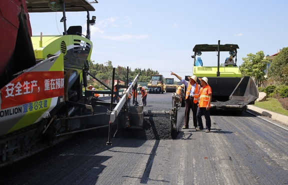 攤鋪機(jī)、壓路機(jī)等設(shè)備緊張有序運(yùn)行，高達(dá)170℃的瀝青混合料炙烤著公路人